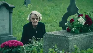 alte Frau bei der Grabpflege