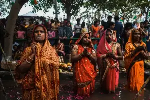 Indische Frauen stehen bis zu den Knien in einem Fluss