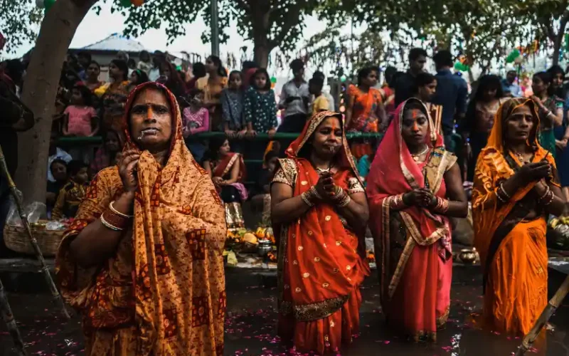 Indische Frauen stehen bis zu den Knien in einem Fluss