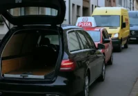 Ein Bestattungswagen blockiert eine Straße, weil die Bestatter einen Toten mit Sarg abholen